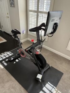 Peloton indoor exercise bike, includes mat & seat cushion